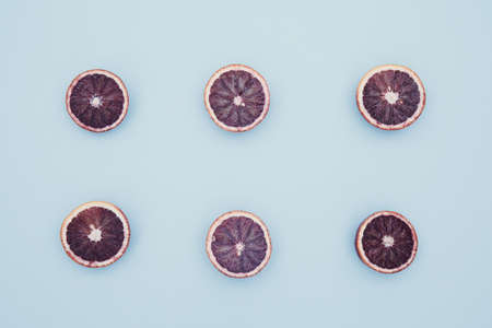 Red oranges on the bold blue background. Creative minimalism and modern food pattern concept....