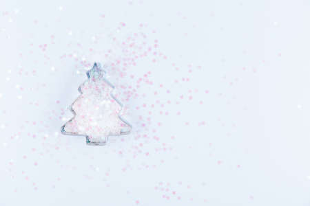 Flatlay with holiday tree cookie cutter and snowflake sprinkles on blue background. Holiday, Christmas and New Year concept. Cozy homey details. Horizontalの写真素材