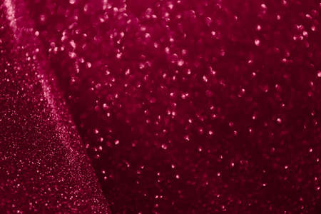 Blurred glitter dark red background for holiday and any project. Shallow depth of field. Horizontal