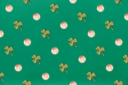 Glitter shamrocks and golden coins on green paper background. St Patricks day symbol. Irish National holiday concept. Horizontalの写真素材