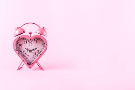 Heart shaped clock on pink background.  Valentines day and love infitity and duration concept. Horizontalの写真素材