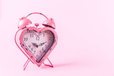 Heart shaped clock on pink background.  Valentines day and love infitity and duration concept. Horizontalの写真素材