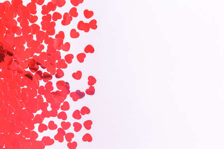 Glitter heart confetti border on light grey. Valentine day concept. Trendy minimalistic flat lay...