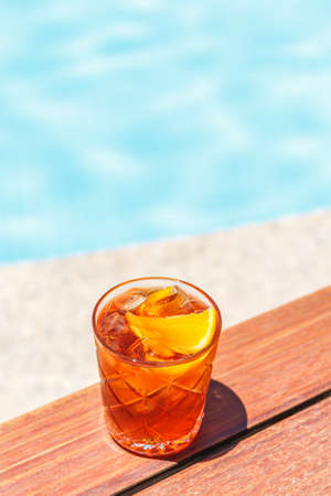 Negroni cocktail  near a pool at the resort bar or suite patio. Luxury resort, vacation, room service concept. Verticalの写真素材