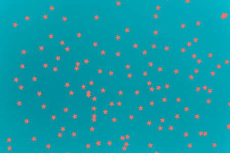 Turquoise multipurpose background with coral star shaped confetti accents. Festive concept....