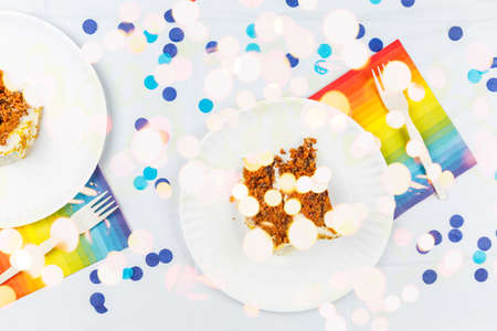 Flat lay with birthday cake pieces on white paper plates. Birthday party celebration concept....