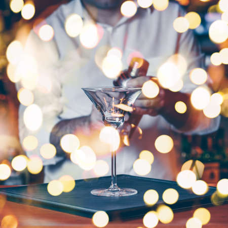 Barman pouring  cocktail at a nightclub. Nightlife and entertainment concept. Square, bold light bokehの写真素材
