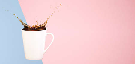 Coffee concept. Minimal art. Solid background. Coffee splashes. Levitating mug. Pink and light blue background. Horizontal, wide screen banner format, straight cupの写真素材