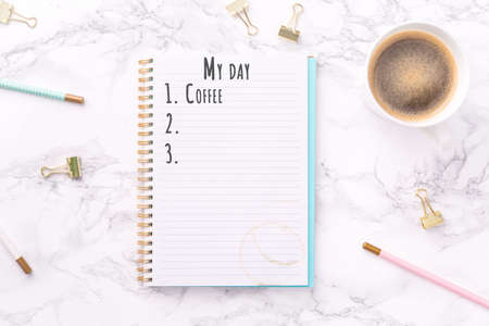 Festive golden stationary and coffee on white marble background. My day - start with coffee wording. Copy space. Top view. Horizontalの写真素材