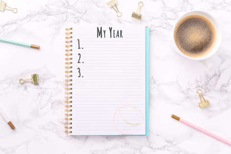 Festive golden stationary and coffee on white marble background. My Year wording. Copy space Top view. Horizontalの写真素材