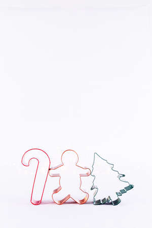 Multicolor cookie cutters on white sparkling background with bokeh lights. Holiday Christmas and New Year background. Verticalの写真素材