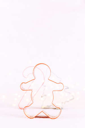 Multicolor cookie cutters on white sparkling background with bokeh lights. Holiday Christmas and New Year background. Verticalの写真素材