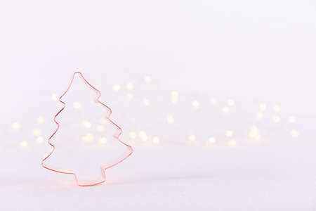 Christmas Tree Copper cookie cutter on white sparkling background with bokeh lights. Holiday Christmas and New Year background. Horizontalの写真素材