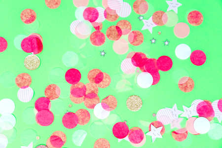Multicolor pink, gold and white confetti on the bold minty green background, holiday celebration backdrop, Flat lay styleの写真素材