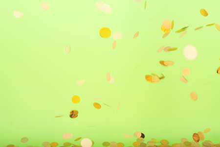 Golden confetti falling on the bold neon green background, holiday celebration backdrop, easy to cut to bannerの写真素材