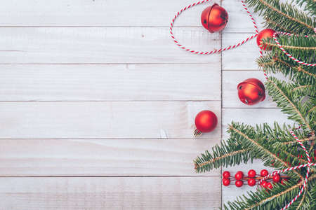 Red holiday bells with Christmas tree on rustic wooden background with ribbon and berries. Holiday season concept. Horizontalの写真素材