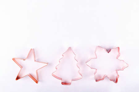 Flatlay with star, snowflake and holiday tree copper cookie cutters on white sparkling background. Holiday, Christmas and New Year concept. Cozy homey details. Flat lay top view background. Horizontalの写真素材