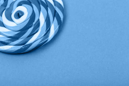 Big blue lollipop on solid blue background. Horizontalの写真素材