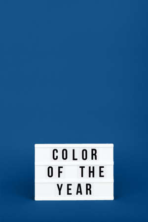 Retro lightbox with Color of the year wording on the trendy solid blue backdrop in vertical format, place for textの写真素材