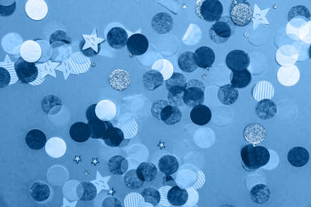 Monochrome blue and white confetti on the bold blue background, holiday celebration backdrop, Flat lay styleの写真素材