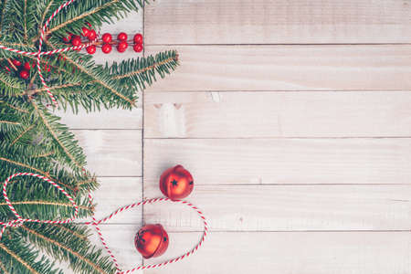 Red holiday bells with Christmas tree on rustic wooden background with ribbon and berries. Holiday season concept. Horizontalの写真素材