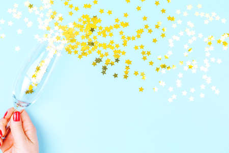 Woman hand with red manicure holding champagne glass. Holiday, party and celebration concept. Horizontalの写真素材