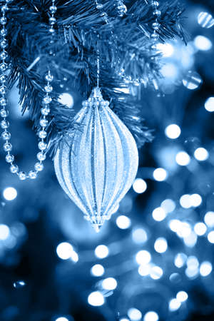 Seasonal background with Christmas toy on the tree. Celebration concept. Soft focus. Vertical, blue toningの写真素材