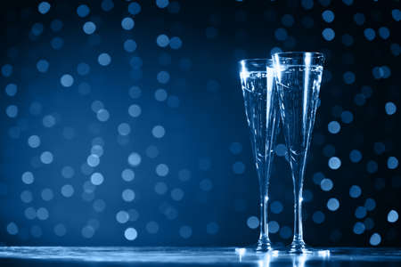 Two glasses of champagne on classic blue bokeh background. Holiday concept. Festive bokeh background. Horizontal, tonedの写真素材