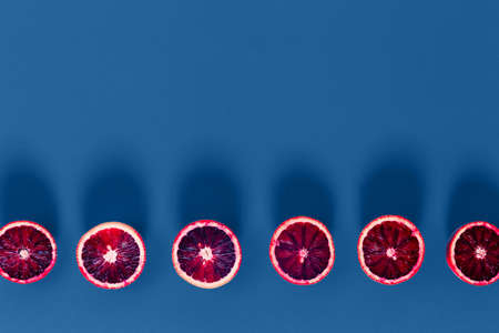 Red oranges on the classic blue background. Creative minimalism and modern food pattern concept. Horizontalの写真素材