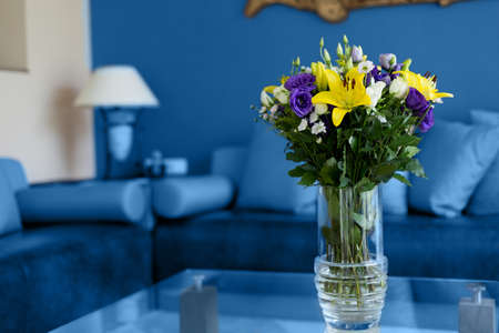 Modern living room interior in classic blue shades with flowers on the coffee tableの写真素材