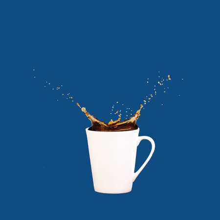 Levitating coffee mug with splashes on solid classic blue background. Coffee concept. Minimal art trend. Squareの写真素材