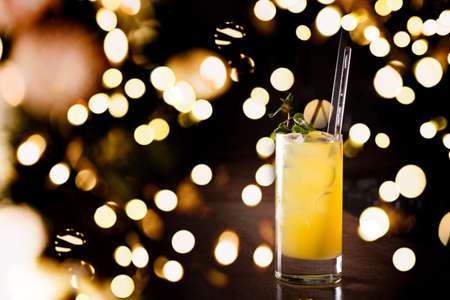 Screw driver cocktail with fresh mint on the dark background. Shallow DOF with festive bokeh lightsの写真素材