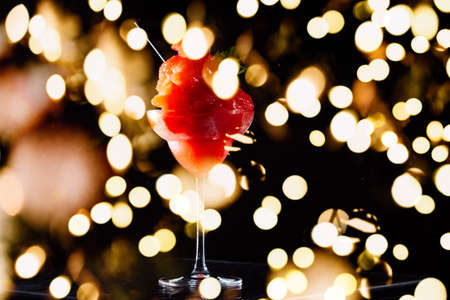 Frozen strawberry margarita on the dark background. Luxury craft drink concept. Horizontal with festive holiday bokehの写真素材