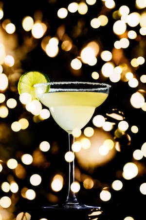 Classic daiquiri on the dark background. Luxury craft drink concept. Vertical with festive holiday bokehの写真素材