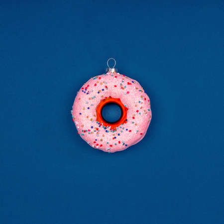 Holiday season card with Christmas tree toy donut on classic blue, place for textの写真素材