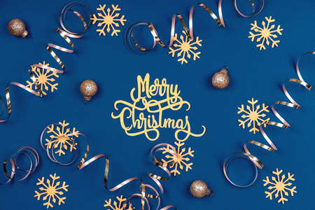Holiday background with Merry Christmas wording, golden snowflakes, balls and ribbons on classic blue. Holiday celebration conceptの写真素材