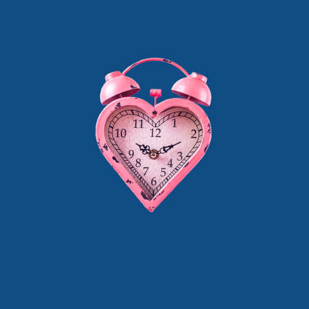 Heart shaped pink clock on classic blue background. Valentines day and love infitity and duration concept. Squareの写真素材