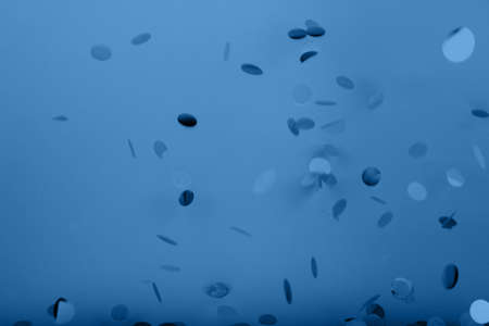 Golden confetti falling on the bold classic blue background, holiday celebration backdrop, easy to cut to bannerの写真素材
