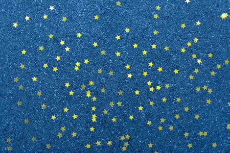 Classic blue textured background with place for text. Horizontal with festive golden star shaped confettiの写真素材