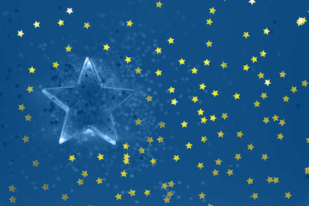 Flatlay with star cookie cutter and snowflake sprinkles on blue background. Holiday, Christmas and New Year concept. Cozy homey details. Horizontal with festive golden star shaped confettiの写真素材