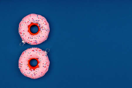 Holiday season card with Christmas tree toy donuts on classic blue, place for textの写真素材