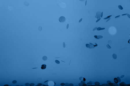 Golden confetti falling on the bold classic blue background, holiday celebration backdrop, easy to cut to bannerの写真素材
