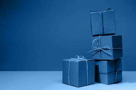 Craft cardboard boxes on the solid classic blue background. Holiday and gift concept. Horizontalの写真素材
