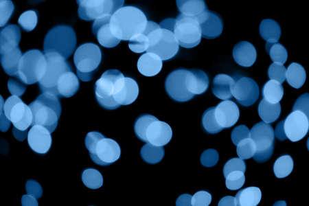 Black background with classic blue bokeh lights. Holiday, Christmas and New Year background. Horizontal, perfect for layeringの写真素材