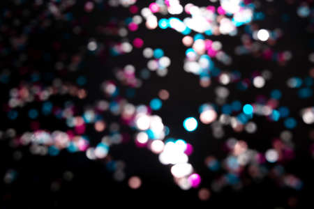 Black background with bright multicolor bokeh lights. Holiday, Christmas and New Year background. Ideal to layer with any design. Horizontalの写真素材
