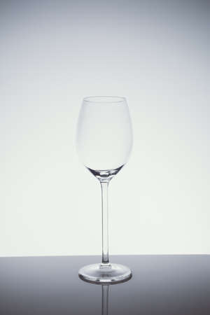 Wineglass on the light background.. Fine cristal glassware concept. Vertical, cold tone in light cold toningの写真素材