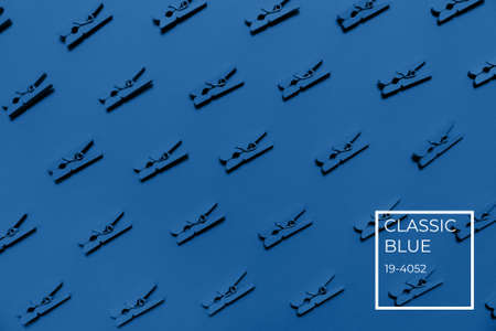 Blue clothes pins on the blue background. Monochrome concept. Horizontal with color name tagの写真素材