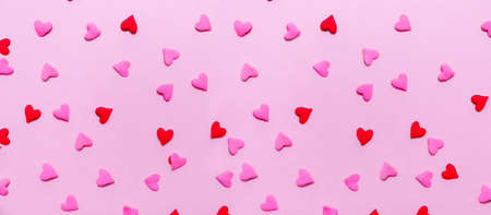Two tone heart sprinkles on the solid pink background. Romance, love, Valentines and mother's day concept. Flat lay, horizontal wide screen banner formatの写真素材