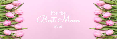 For the best Mom ever wording with pink tulips on the pink background. Flat lay, top view. Mothers day holiday celebration card. Horizontal, banner formatの写真素材