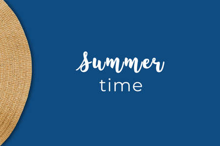 Overhead view of straw hat detail on the classic blue background with Summer time wordingの写真素材